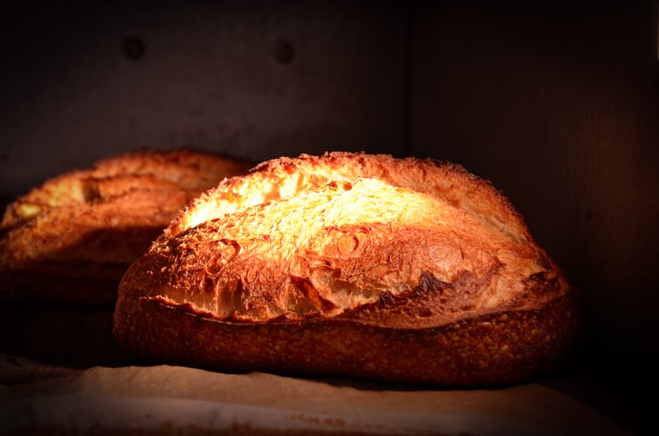 Golden artisan bread fresh out of the oven with a crispy crust, highlighting traditional baking techniques.
